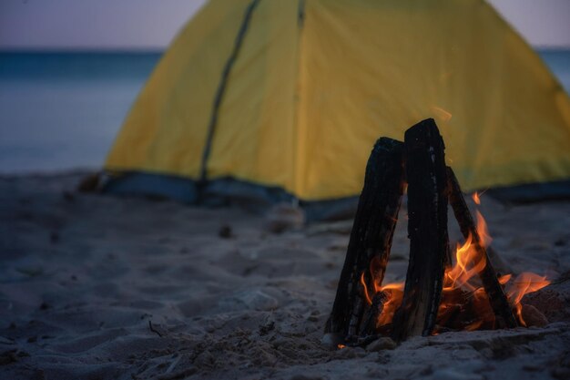 Fire in bonfire in the beach Camping and tents to travel