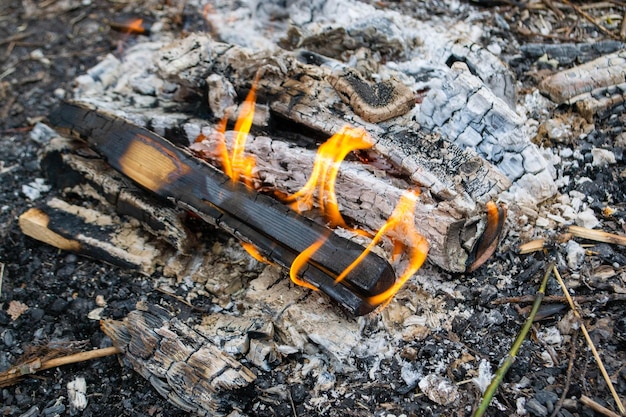 A fire burns in a campfire with a flame in the foreground