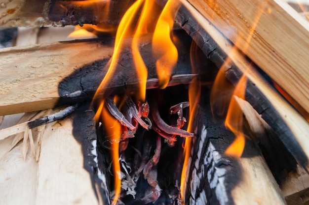 Photo a fire burns in a campfire with a red fire in the background