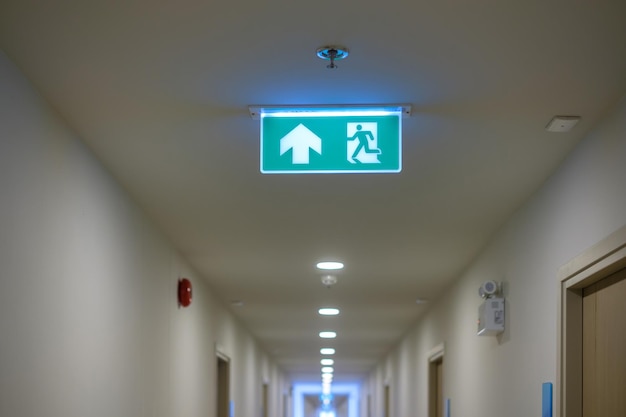Photo fire emergency exit sign on the wall background inside building safety concept