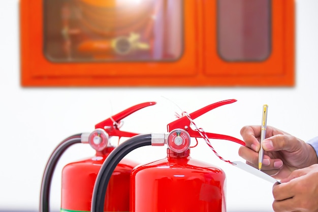 Fire engineering checking pressure gauge level of fire extinguisher