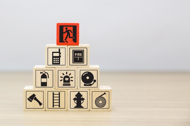 Fire exit and safety icons on wooden toy blocks stacked.