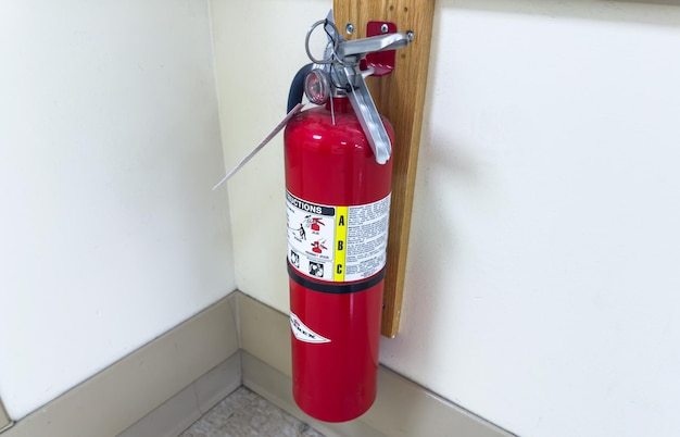 白い壁に消火器があり、緊急時の安全性と備えを象徴しています。