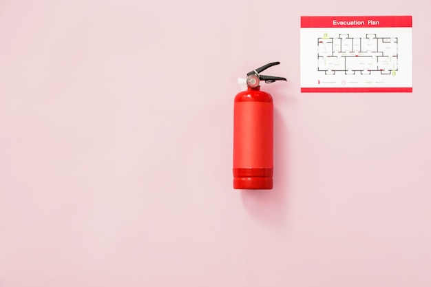 Fire extinguisher and evacuation plan on pink wall