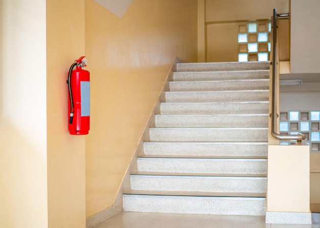 A fire extinguisher hangs up the stairs Fire safety concept