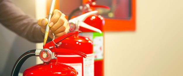 Fire extinguisher has hand engineer checking pressure gauges