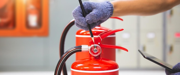 Fire extinguisher has hand engineer checking pressure gauges