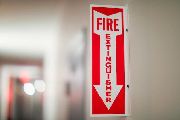 Photo fire extinguisher and sign depicting safety urgency preparedness red color prevention emergency