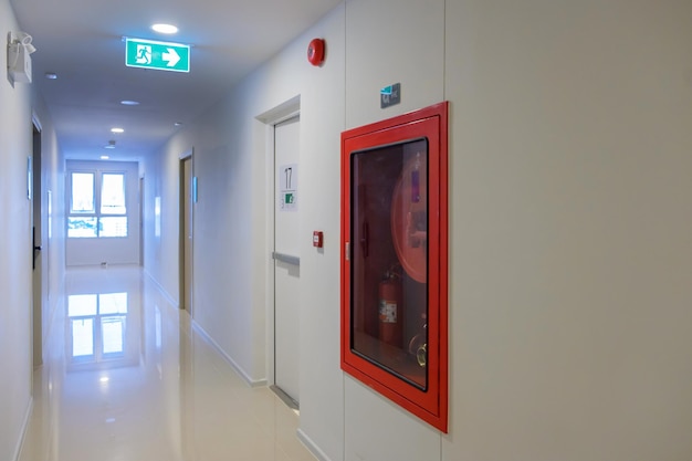 Fire extinguisher system on the wall with Fire Exit door sign for emergency Stairwell fire for escape in building or apartment