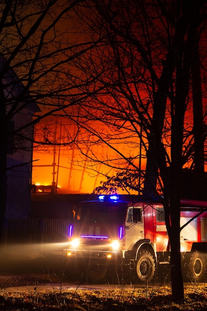 Fire in factory building at night. firefighters try to put out the fire