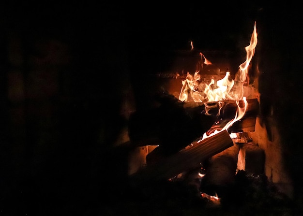 A fire in a fireplace is lit up with a black background.