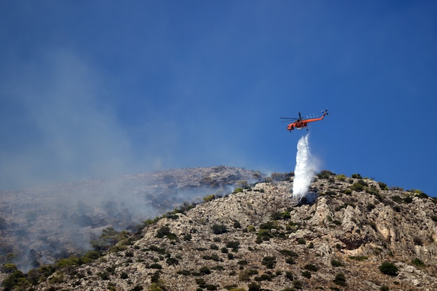 Foto l'elicottero antincendio estingue il fuoco sulla collina. grecia. la fine dell'estate