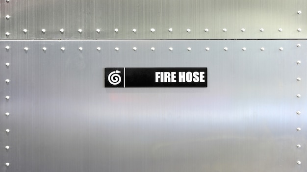 Photo fire hose label against metal wall