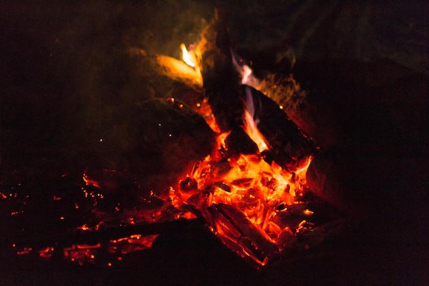 Fire and hot coals in a campfire near the tent