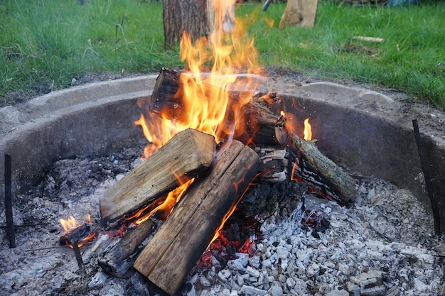 A fire pit with a wood burning in the middle Campfire in the garden