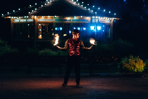 Photo fire show. professional male dancer fakir with a fiery sparkling torch