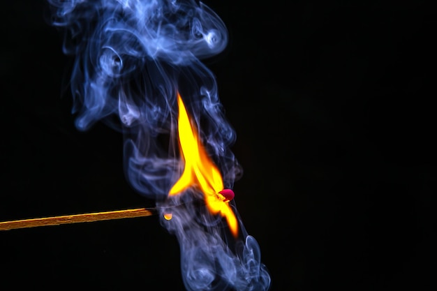 Fire and smoke Burning and smoking match on a black background Heat and light from fire flame