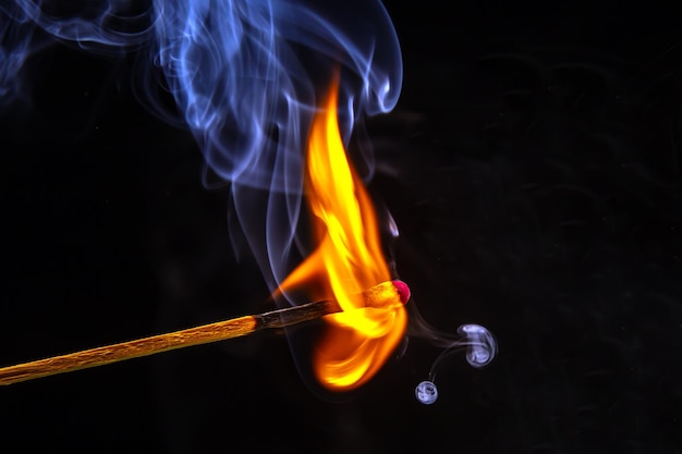 Fire and smoke Burning and smoking match on a black background Heat and light from fire flame