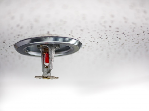 Fire sprinkler on the ceiling of the room.