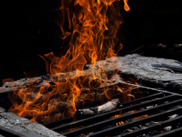 Fire tongues on lattice in bonfire in darkness