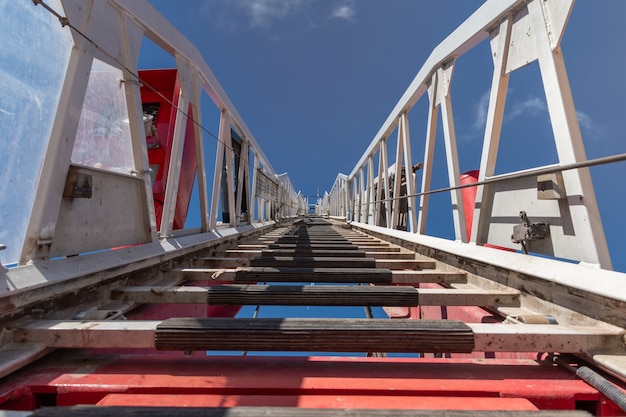 Foto scala del camion dei pompieri che porta al cielo.