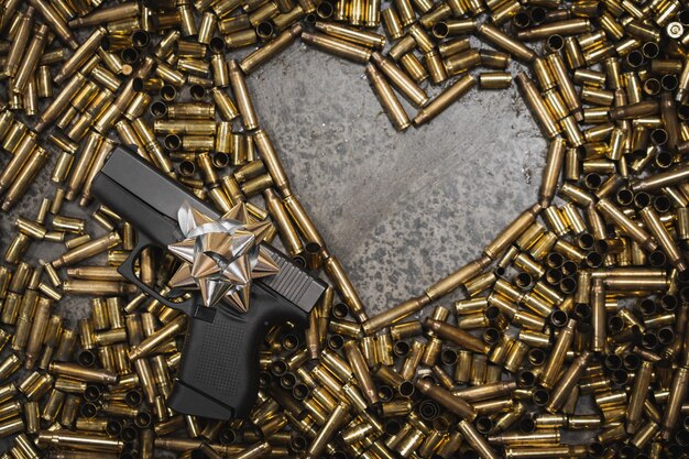 Photo firearm holiday theme heart and cartridge case and small gun with bow