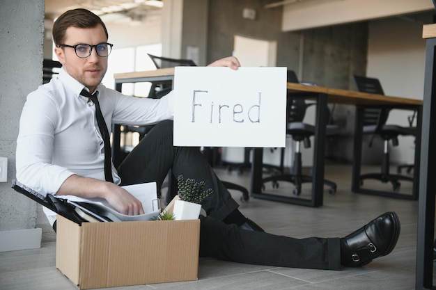 Photo fired employee holding fired sign in hand