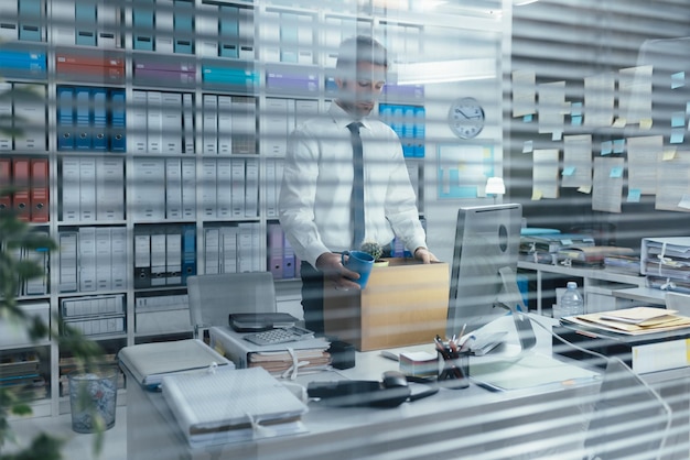 Photo fired office worker holding a box