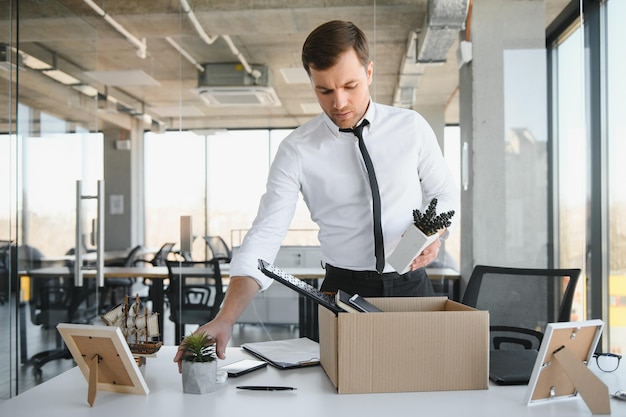 Fired young man packing his stuff in office