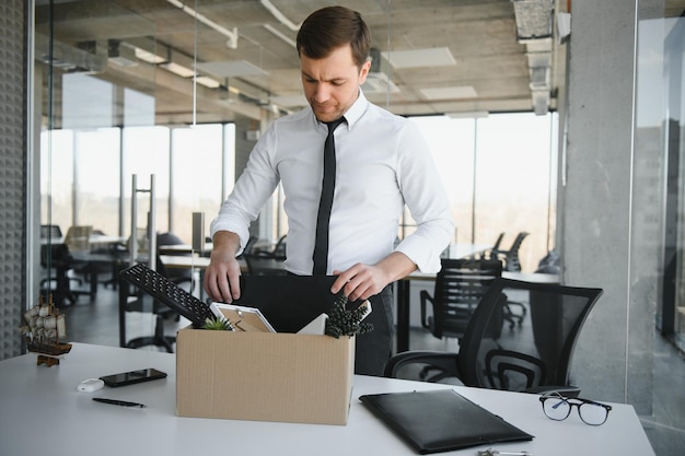 Fired young man packing his stuff in office