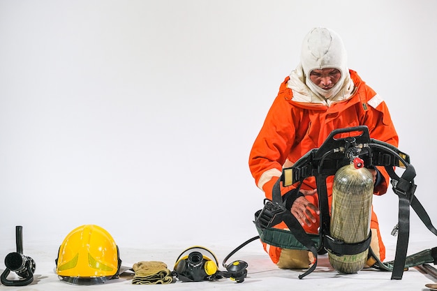 Firefighter demonstrates wearing uniforms, helmets and various equipment to prepare firefighters on a white background.