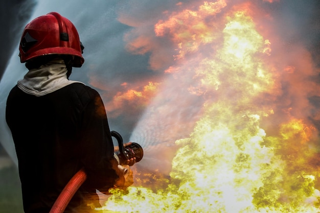 Foto pompiere pompiere un pompiere forte e coraggioso inietta acqua contro il fuoco feroce