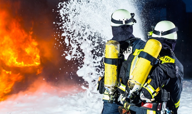 Photo firefighter, firemen extinguishing a large blaze