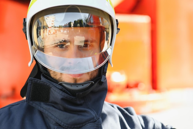 Firefighter portrait on duty Photo fireman with gas mask and helmet near fire engine