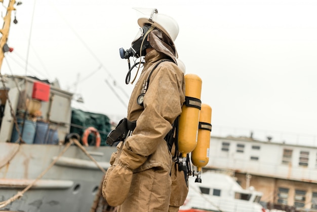 Firefighter in sea port with equipment on a training how to stop fire