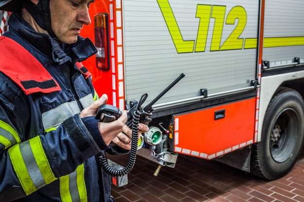 Firefighter standing by fire engine