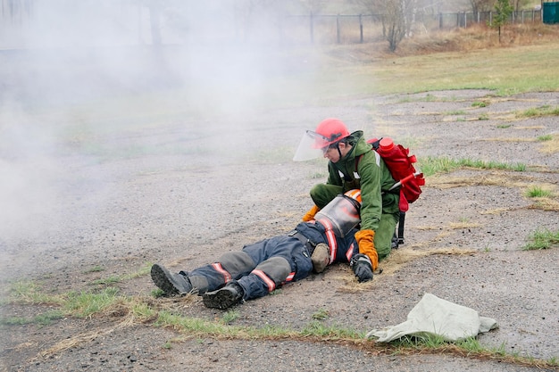 Photo firefighter training to rescue a dead person in the fire fighting training