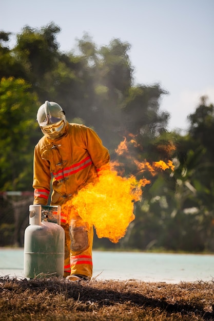 Pompiere con fuoco e tuta per proteggere i vigili del fuoco per addestrare i vigili del fuoco