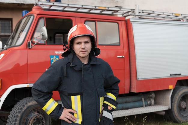 Firefighter with uniform and helmet stand in front of electric wire on a roof top. high quality photo