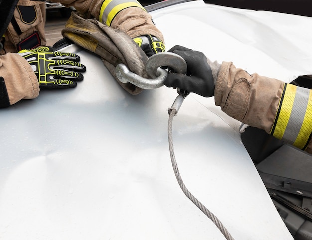 Firefighters hands attaching hooks with slings