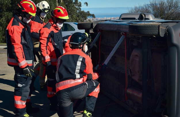 Photo firefighters rescuing a victim from a car during an accident