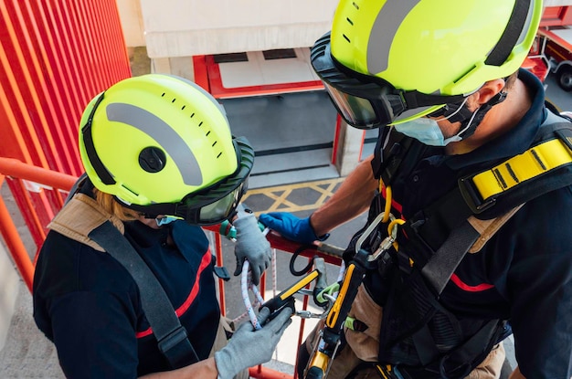 Firefighters reviewing tools in vertical rescue practices during a training exercise Rescue concept