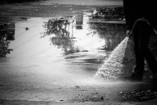 Пожарные разбрызгивают воду на пол - монохромный