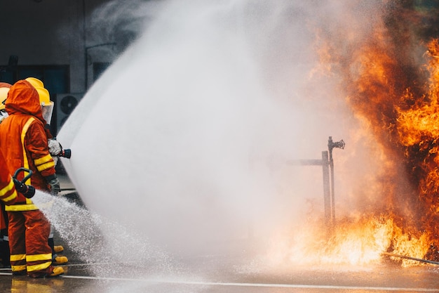 Photo firefighters spraying water on fire on street