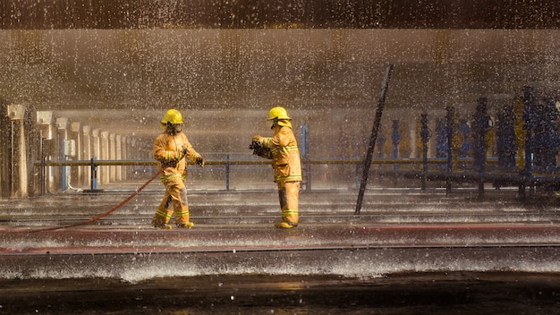 Firefighters training, blur foreground is drop of water springer