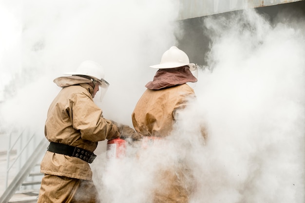 Firefighters use extinguishers on a training how to stop fire in a dangerous mission