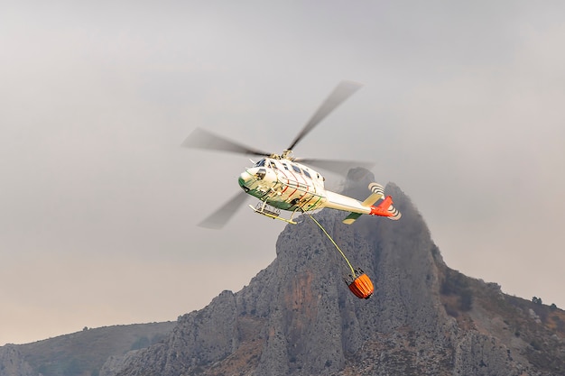 사진 guadalest 저수지에서 물을 모으는 소방 헬리콥터