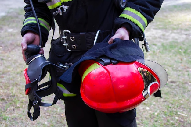 消防士 ヘルメットとマスクを付けた消防士の手