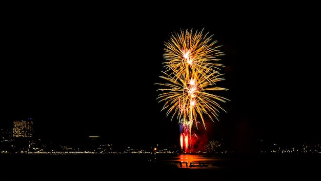 黒い暗い空を背景に花火お祝いパーティー メリー クリスマスと新年あけましておめでとうございます祭明るい明るいボケ味ゴールド抽象的なバースト火記念日誕生日休日壁紙カラフルな夜