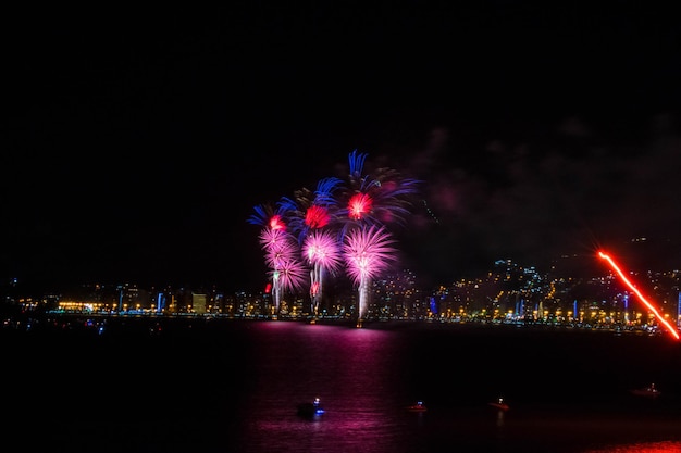 Foto spettacolo di fuochi d'artificio sulla città illuminata contro il cielo notturno